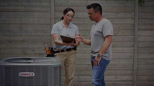 HVAC technician discussing maintenance with homeowner